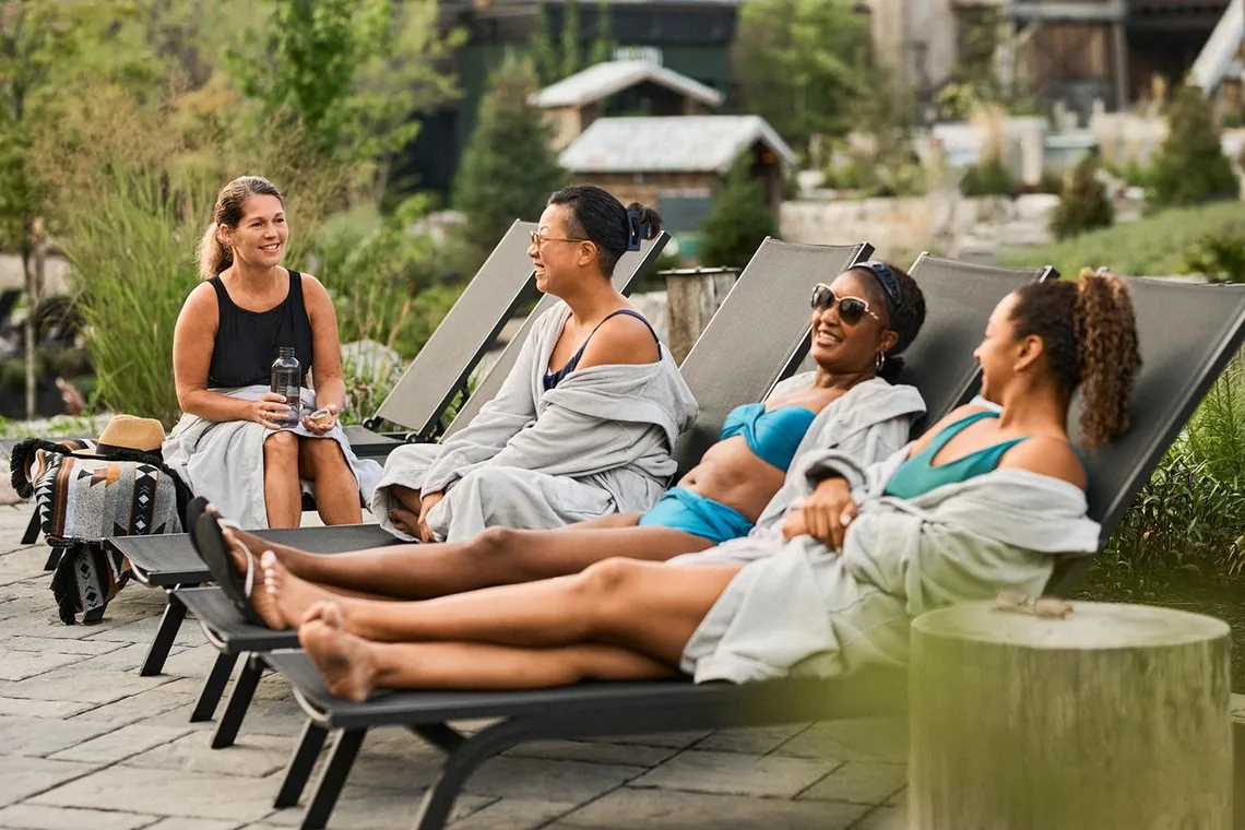 guests resting by the pond in the Spa Village