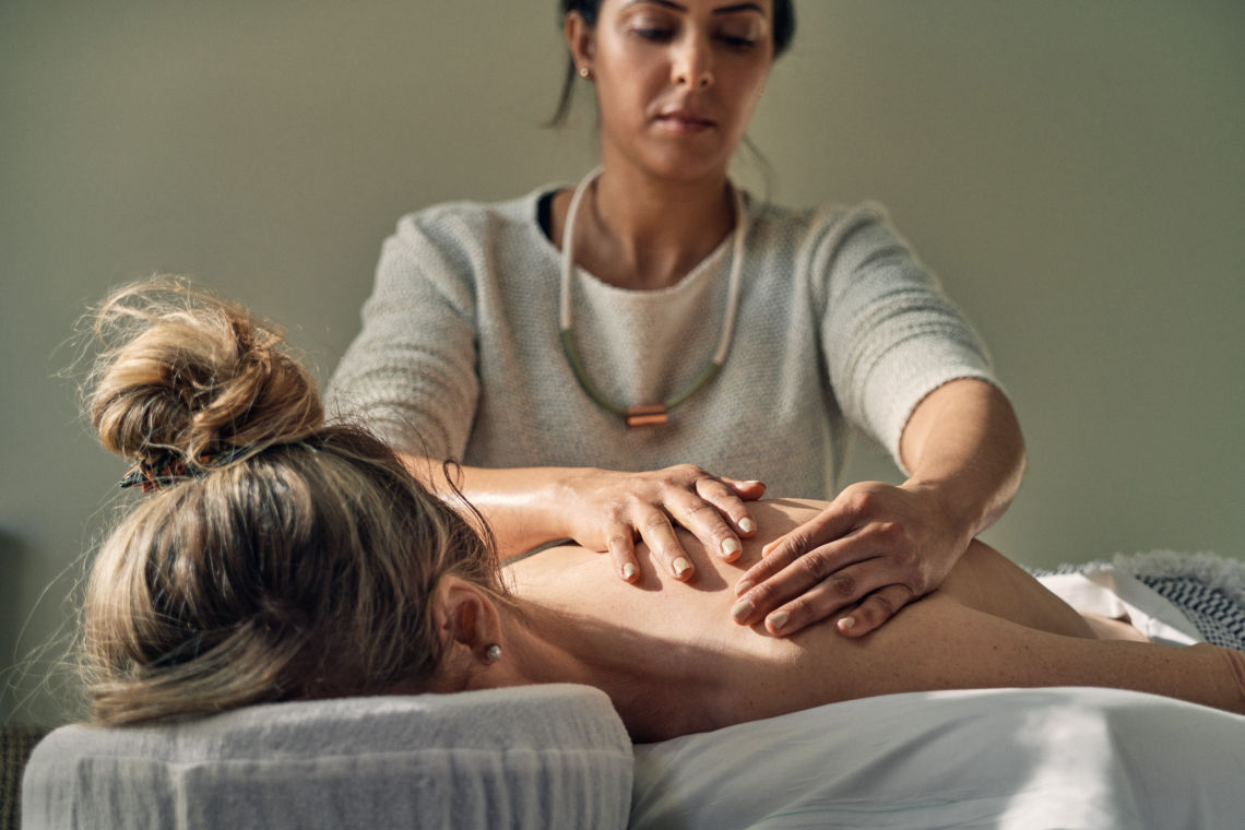 massage therapist giving a back massage