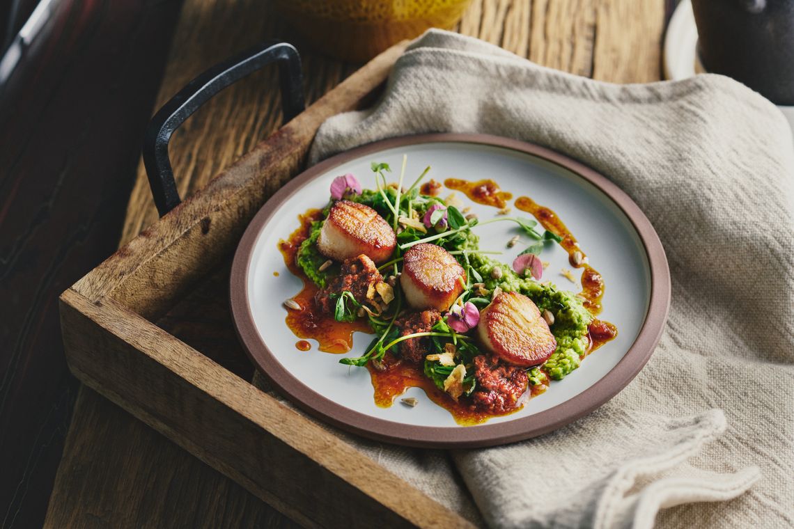 plate of three scallops on vegetables