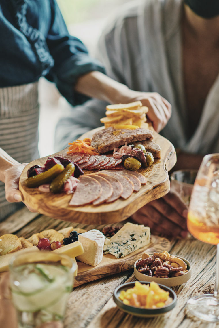 charcuterie and cheese board held above a table