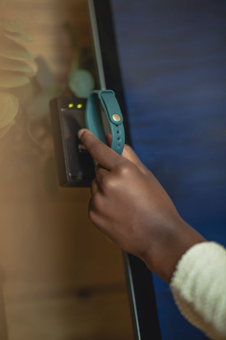 guest scanning their bracelet at a check in kiosk