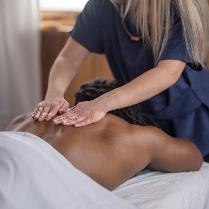 woman laying down receiving a back massage