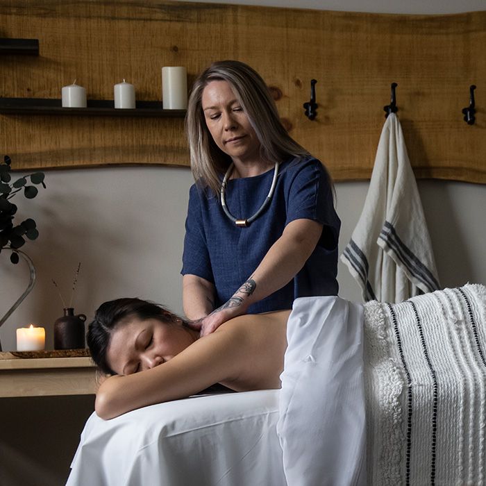 woman laying down receiving a back massage from a massage therapist