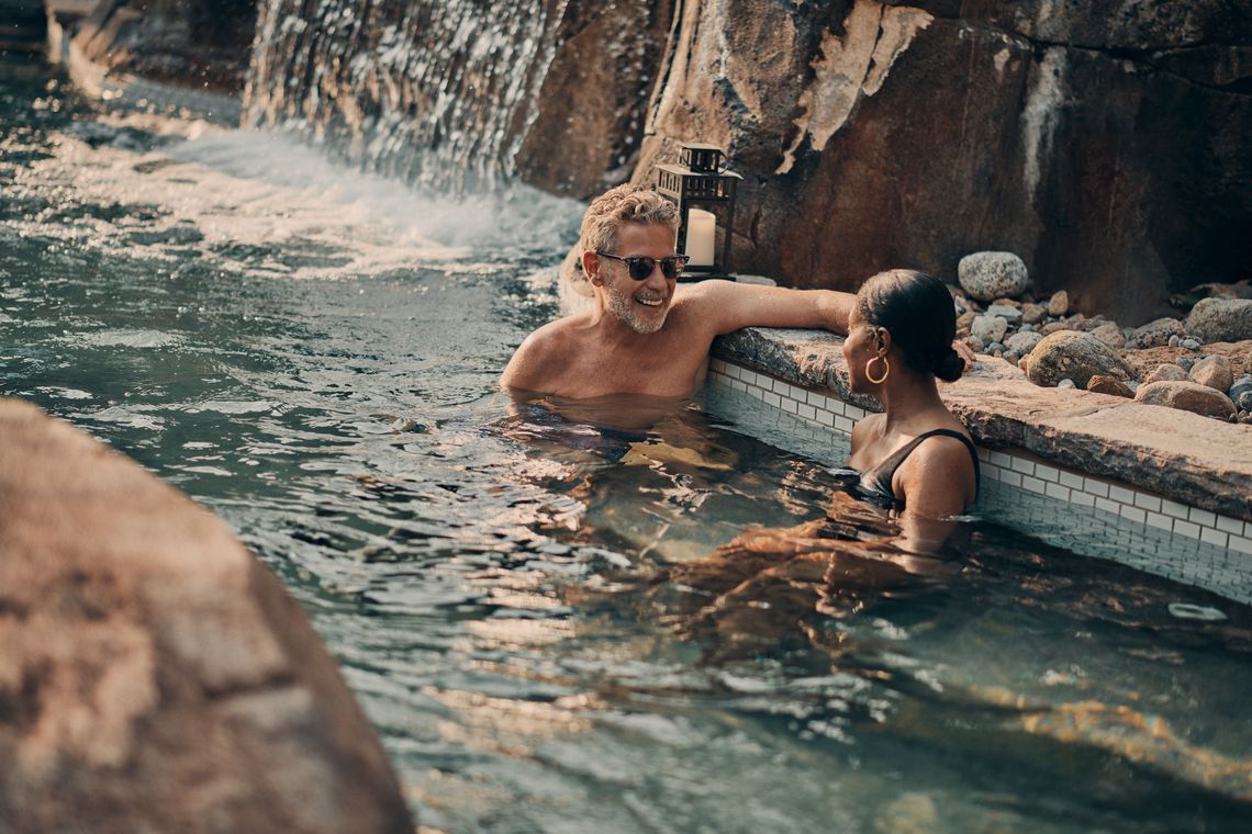 man and woman sitting in an outdoor thermal bath