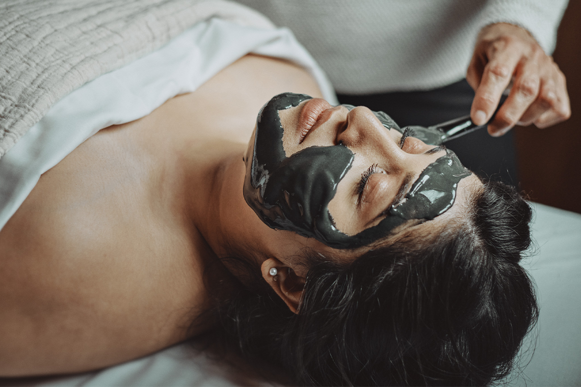 woman receiving a charcoal mask