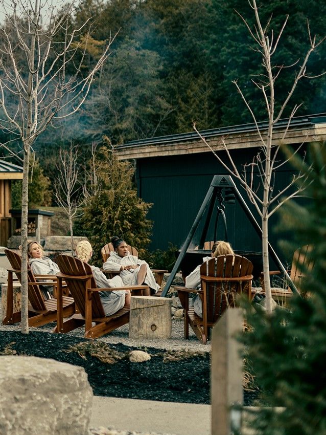 women sitting at an infusion fire pit outside