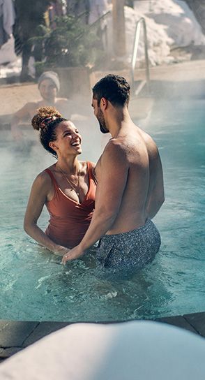 couple looking at each other in an outdoor thermal bath
