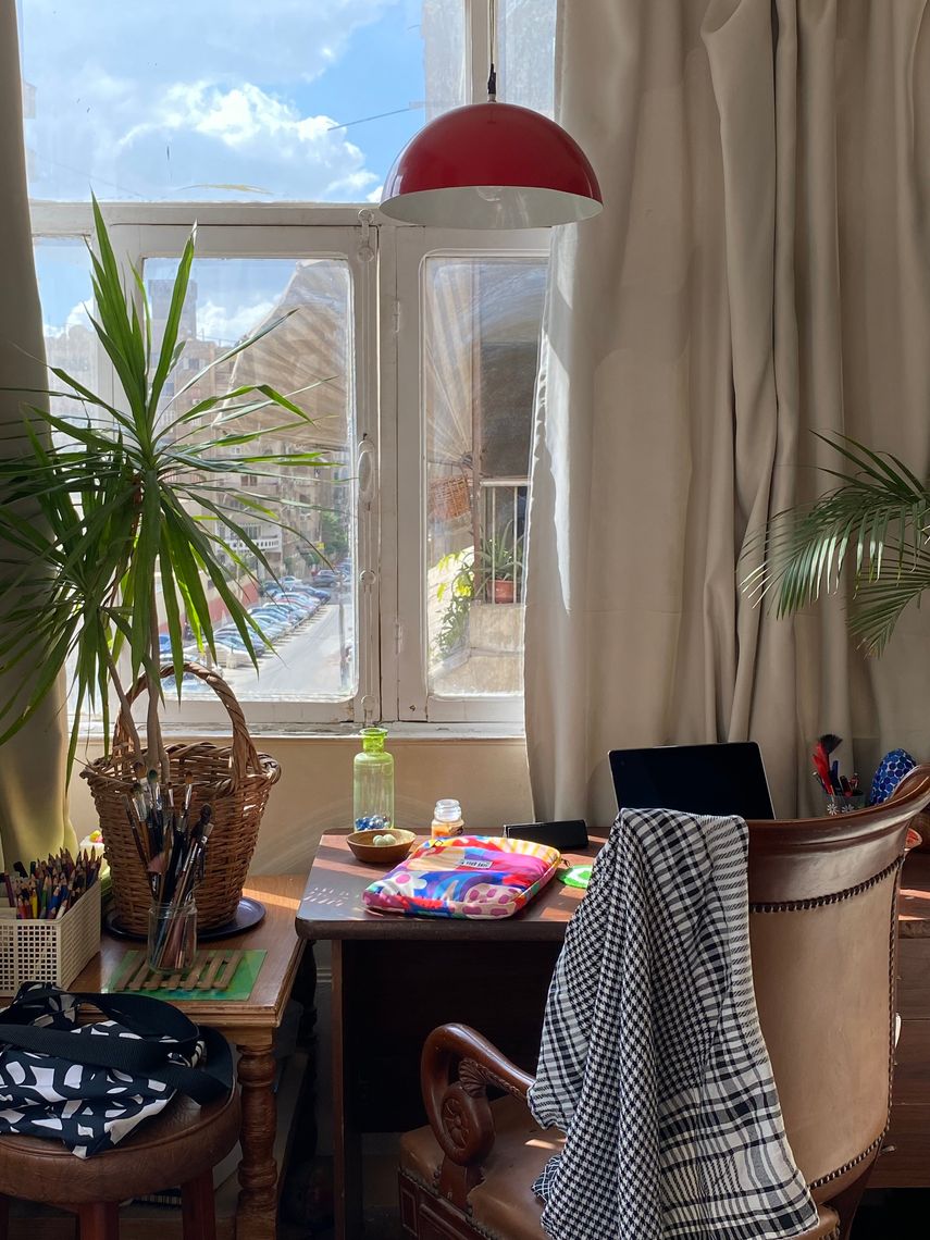 working space by a window with a laptop, books and a plant