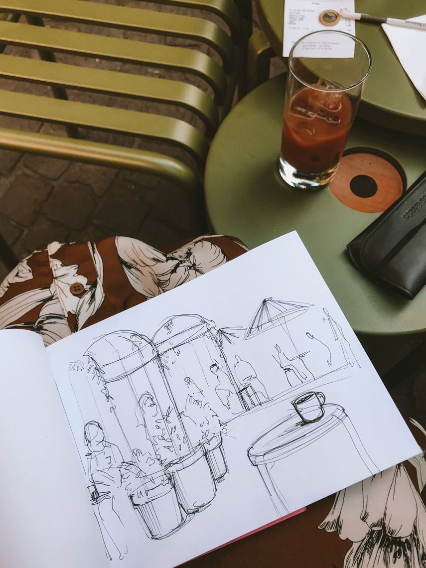 sketch of a coffeeshop in a sketchbook on a woman's knees