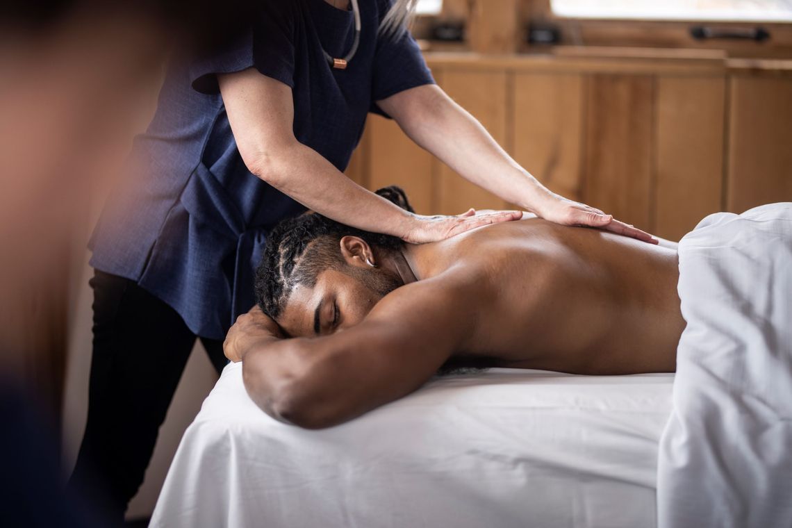 man enjoying a massage in an outdoor cabin