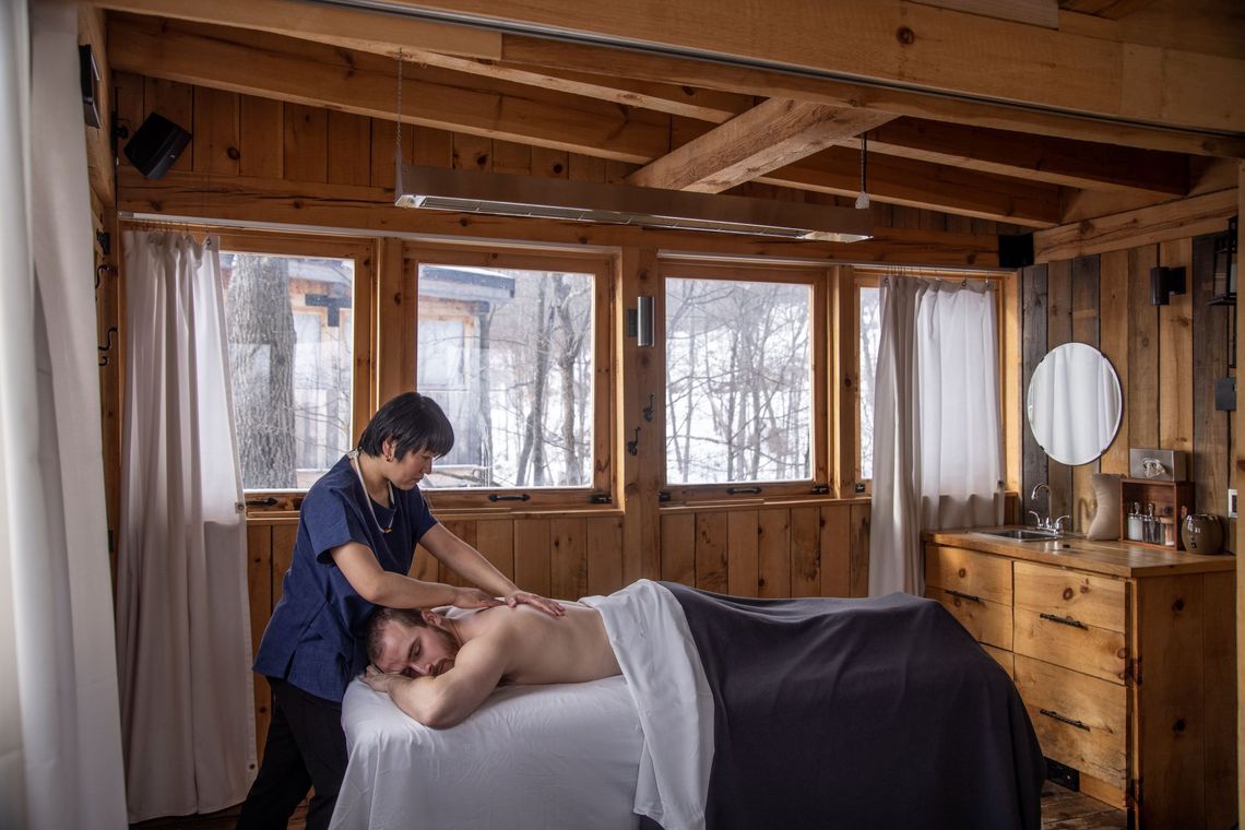 man enjoying a massage in an outdoor cabin