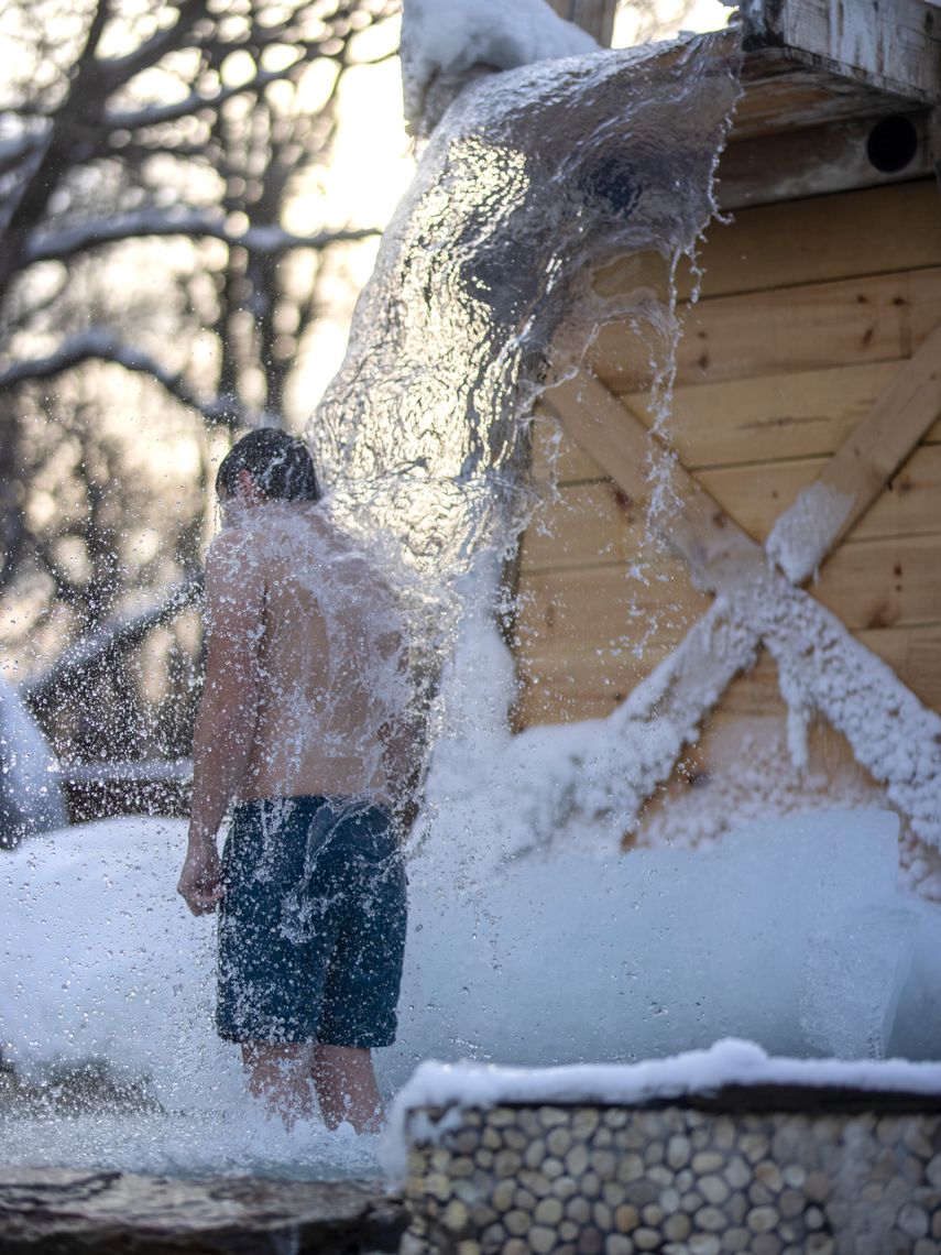 man under a cold waterfall