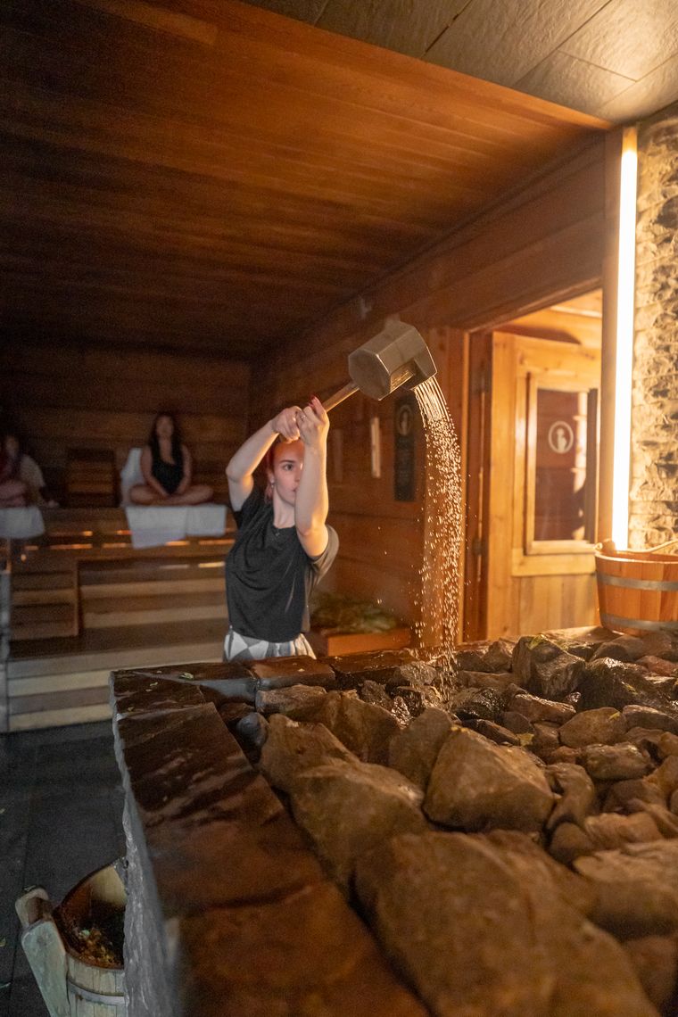 Quincy pouring water on a sauna stove
