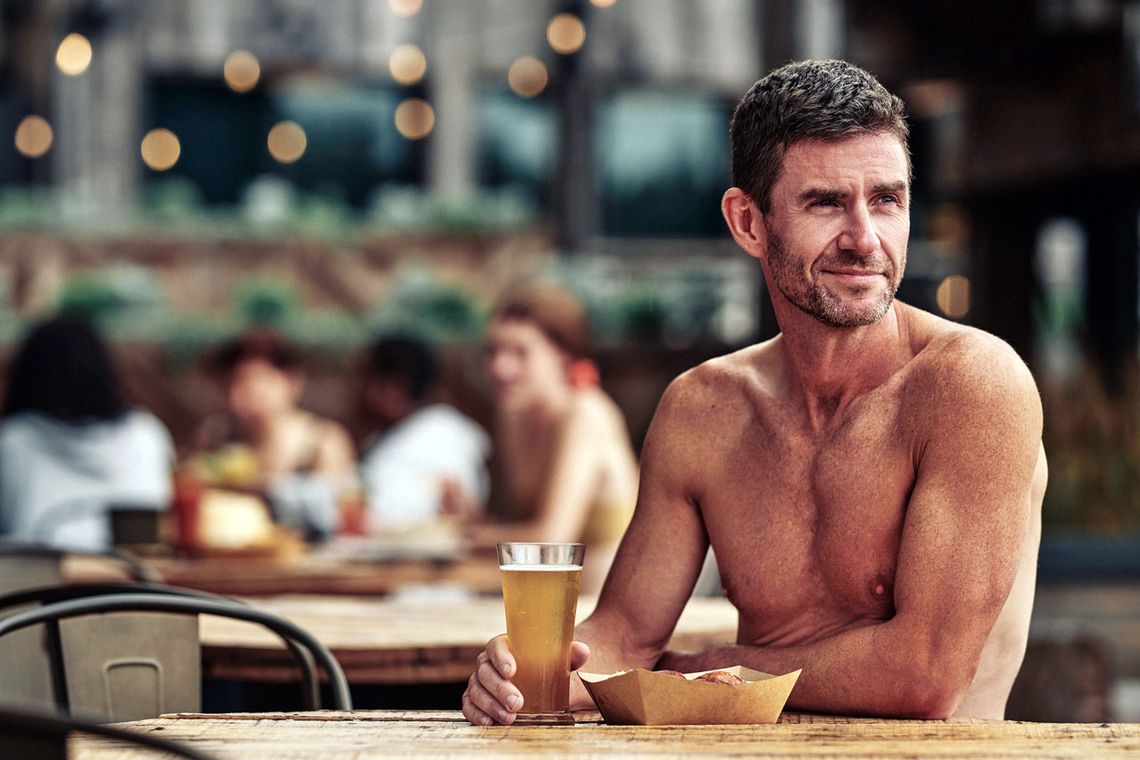 man relaxing at the Spa Village with a beer in hand