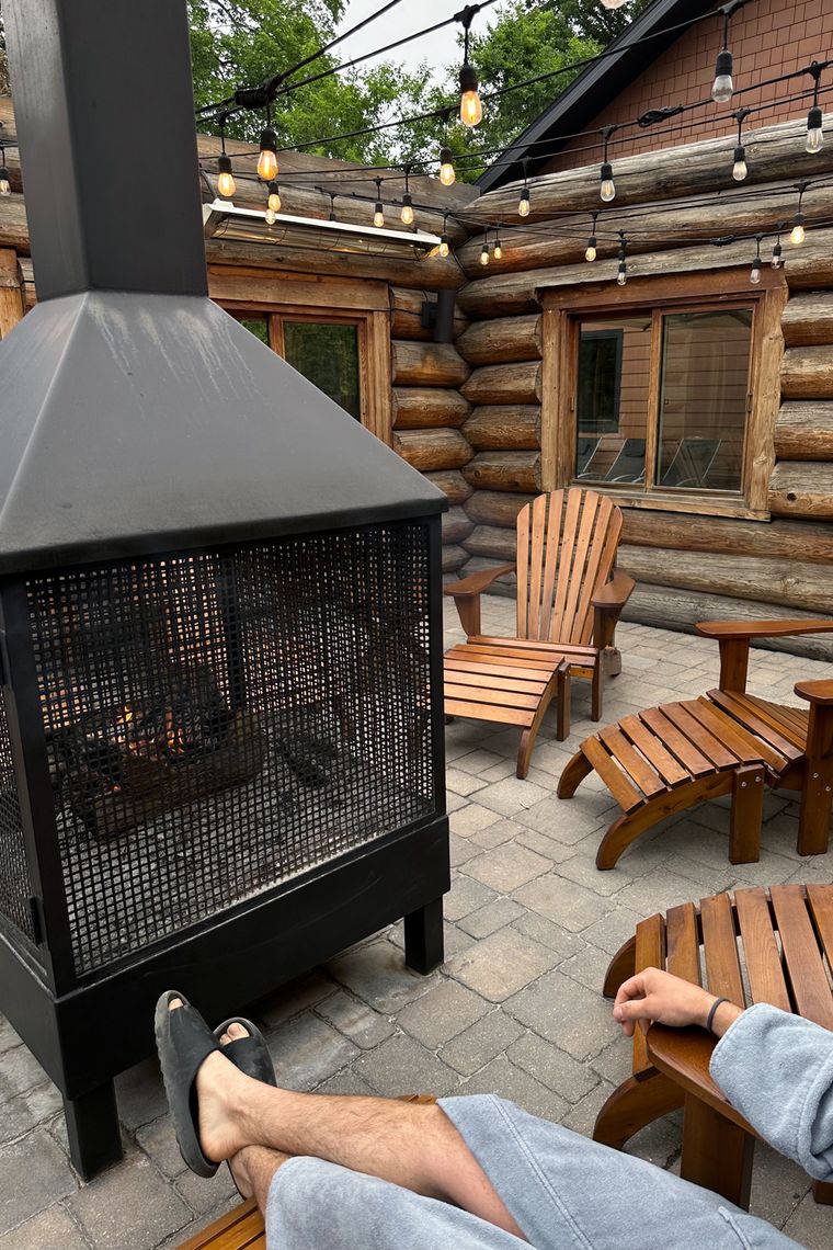 man resting by an outdoor fireplace