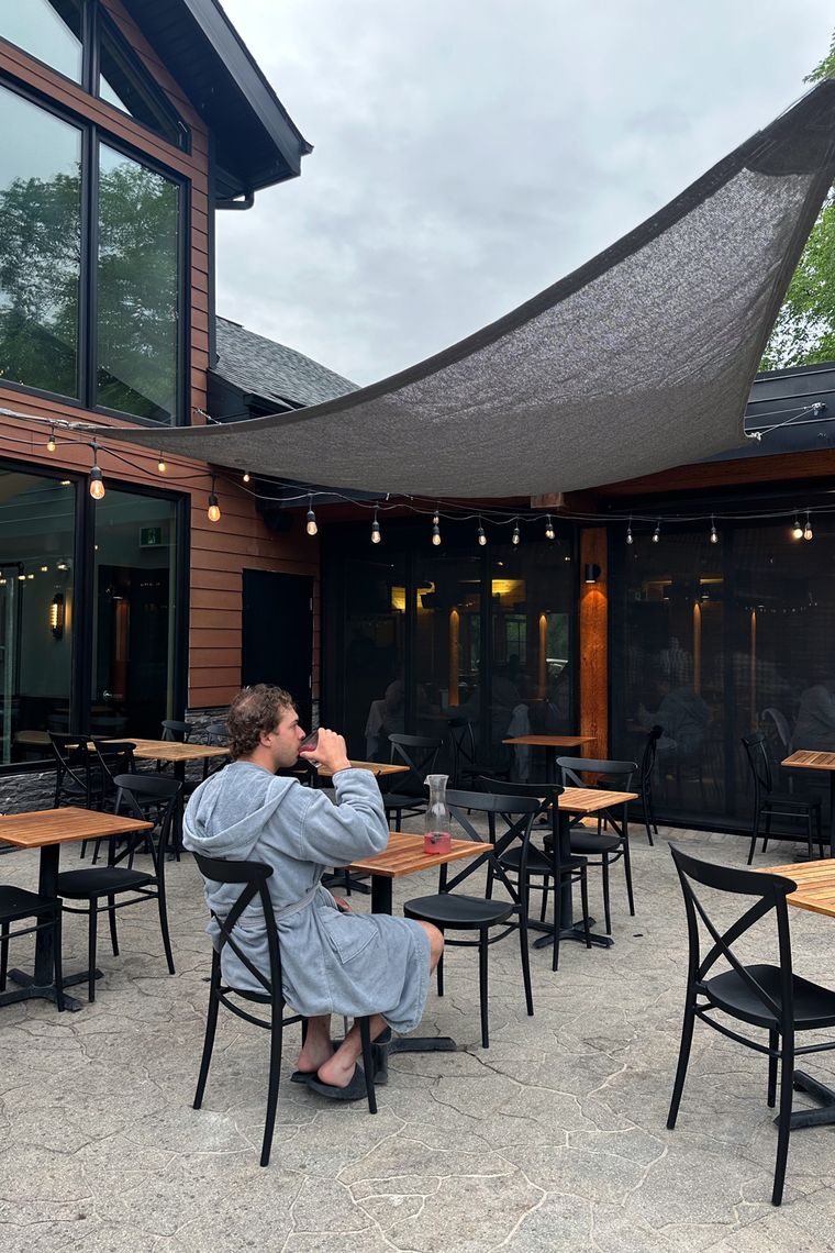 man drinking in an outdoor patio setting