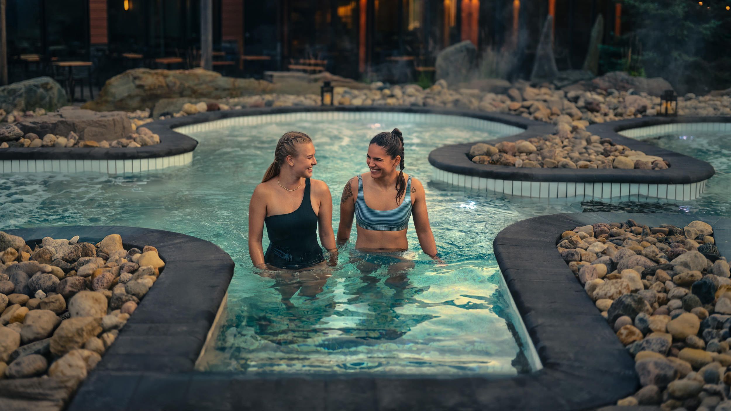 friends in a hot bath with view of lounge and patio in the background