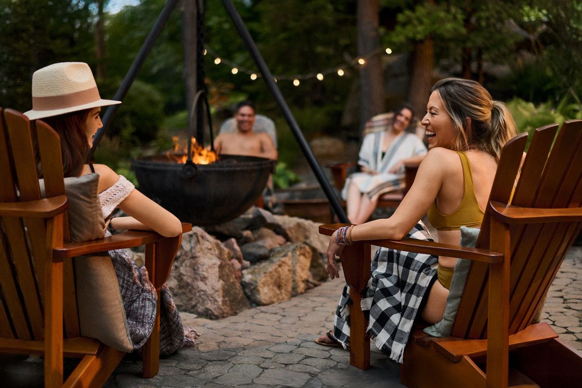 guests sitting around an outdoor fireplace