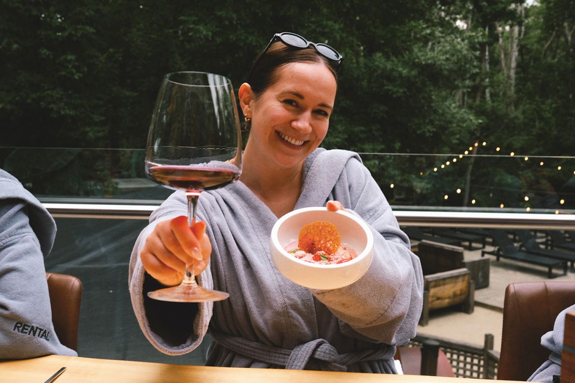 guest holding up a glass of wine and the strawberry preserve