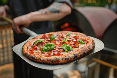 Chef Darnell presenting a pizza
