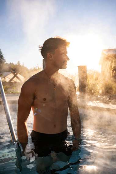 man entering a thermal bath on a foggy morning