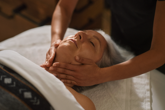 elderly woman enjoying a face care treatment