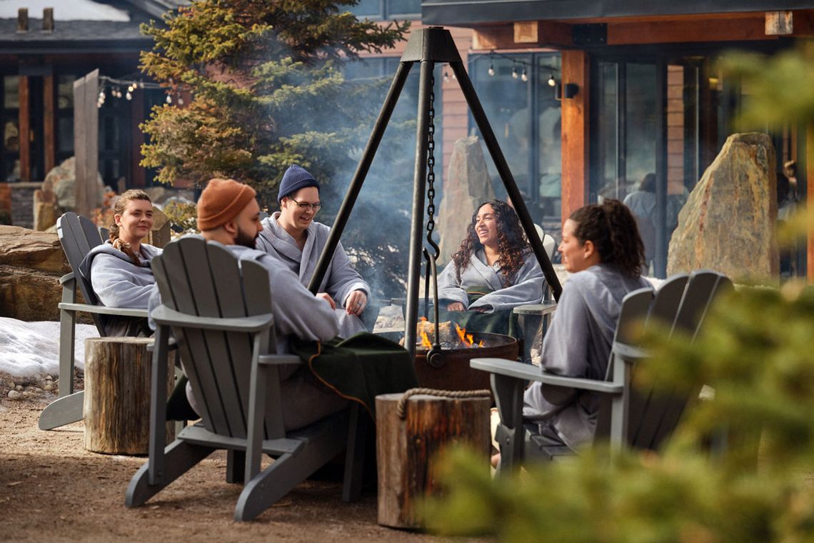 guests sitting around a fire cauldron