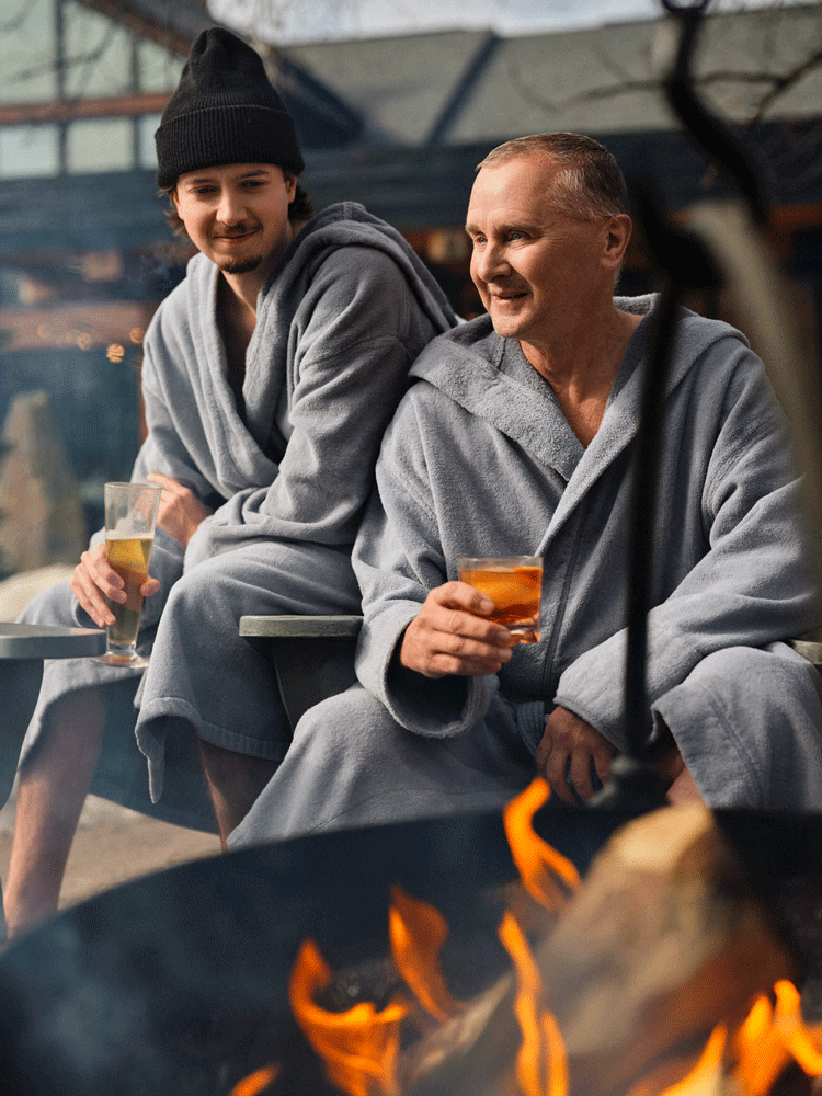 guests with drinks by a fire cauldron